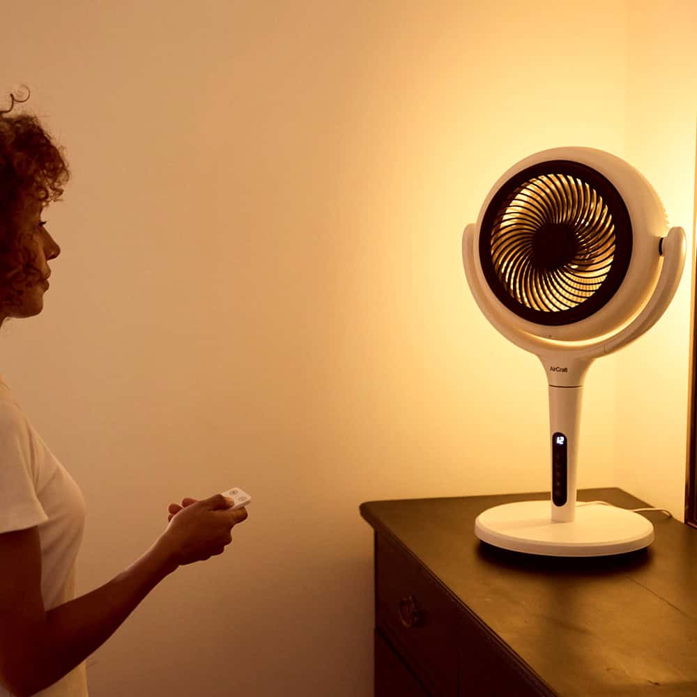 Woman using a remote control to switch on the light of a LUME fan